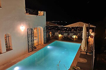 A large swimming pool is lit up at night