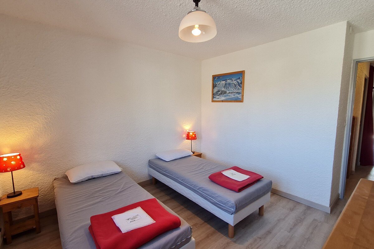 A bedroom with two beds and a picture on the wall