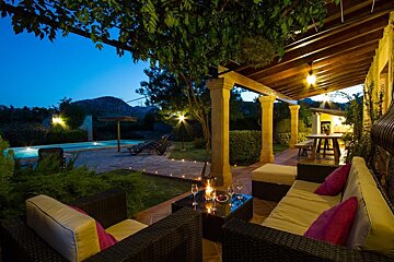 A stone house with brown shutters on the windows