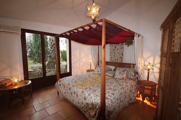 A bedroom with a canopy bed and two lamps