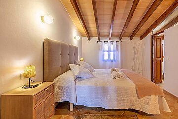 A bedroom with a wooden ceiling and a bed