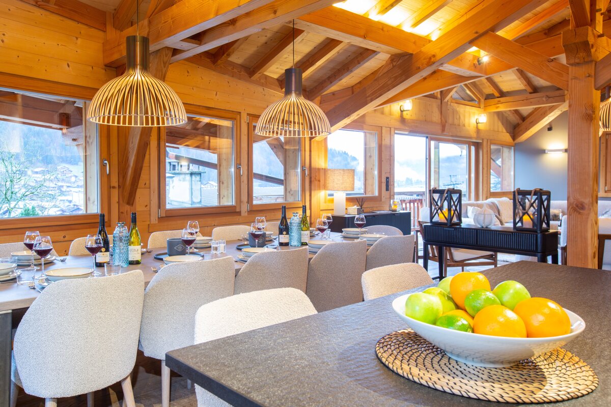 A bowl of fruit sits on a table in a dining room