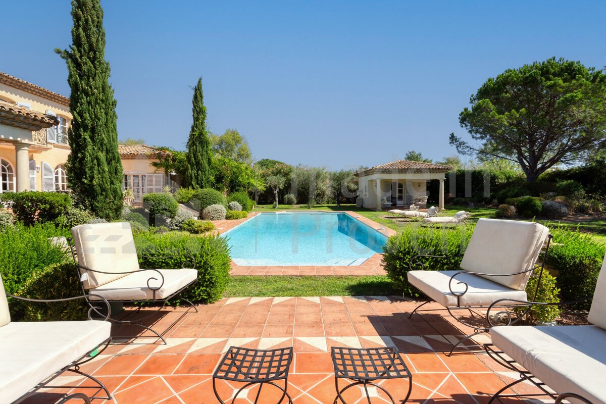 A large swimming pool with a house in the background