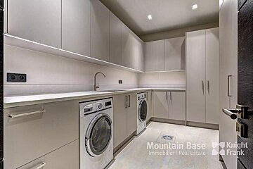 A laundry room with a washer and dryer and a sign that says mountain base