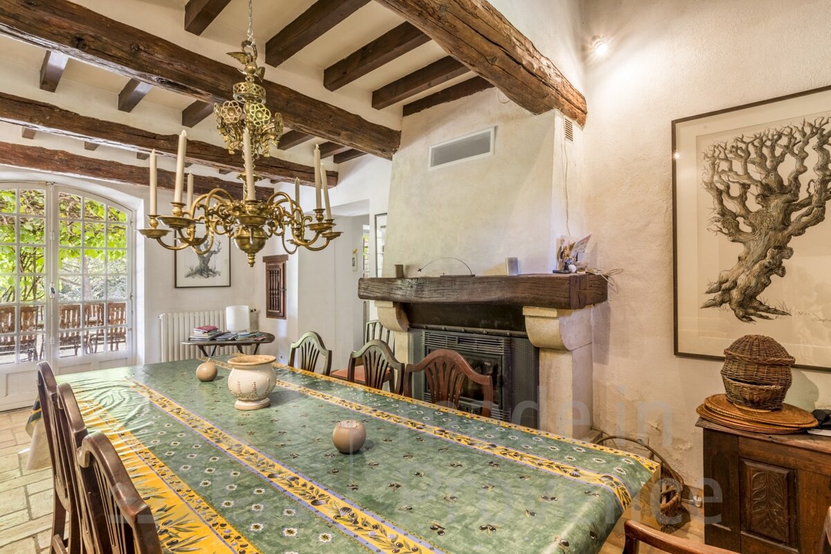 A dining room with a green table cloth and a fireplace
