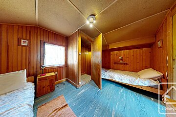 A bedroom with two beds and a sign that says alpine-pro