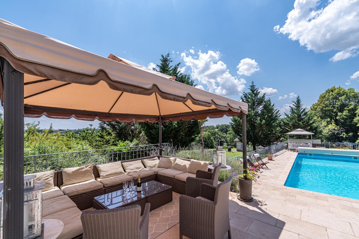 A patio area with a canopy and a swimming pool