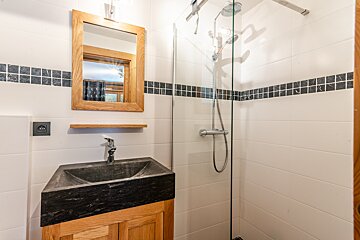 A bathroom with a sink a mirror and a shower