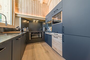 A kitchen with blue cabinets and wooden floors