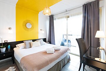 A hotel room with a large bed and a sliding glass door