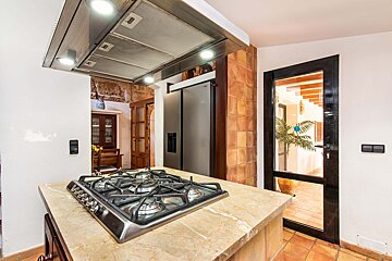 A kitchen with a stove top oven and a refrigerator