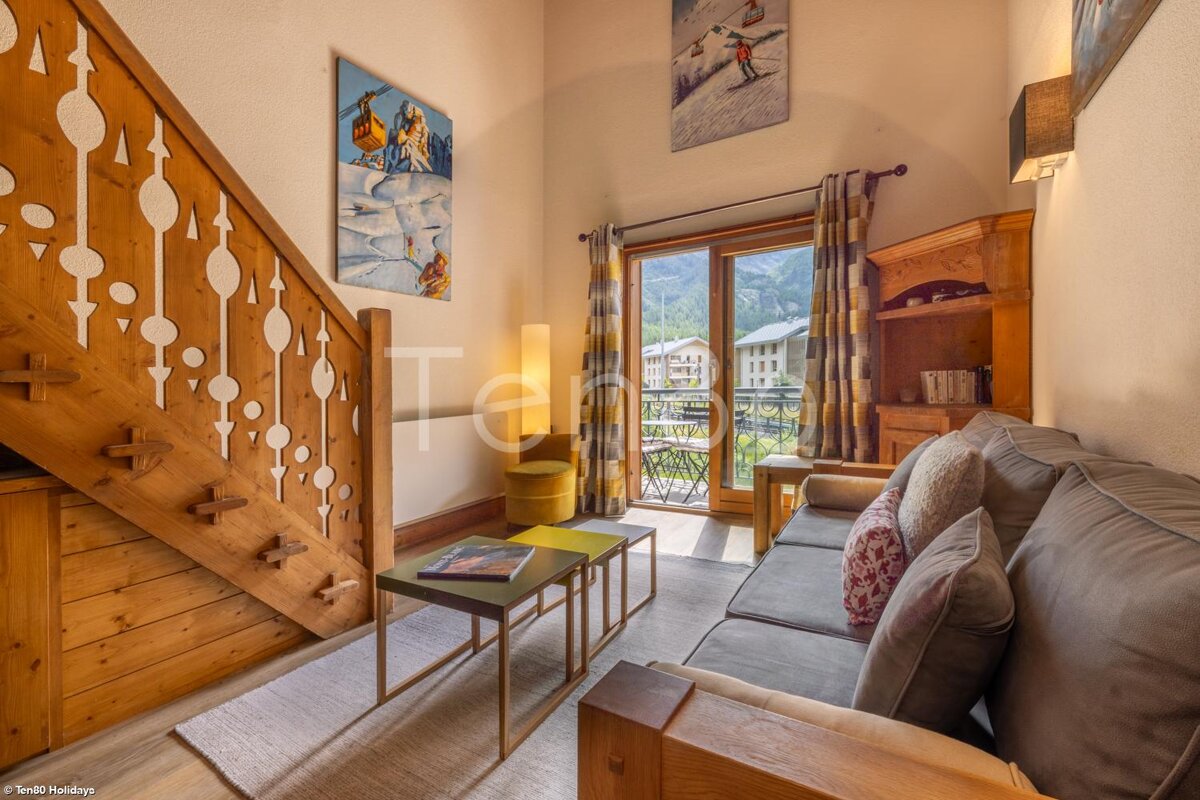 A living room with a wooden staircase and a couch