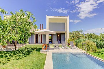 A house with a swimming pool in front of it