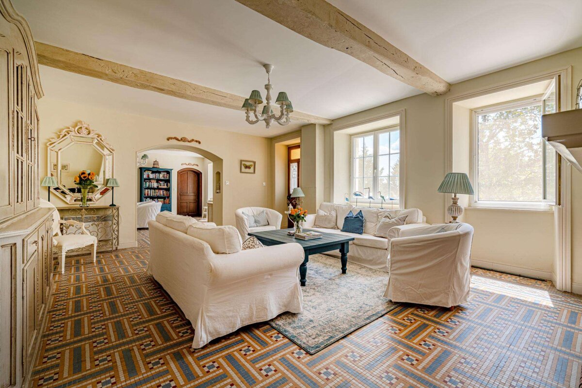 A living room with white furniture and a tiled floor