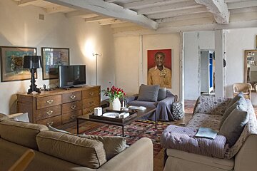 A living room with a painting of a man on the wall