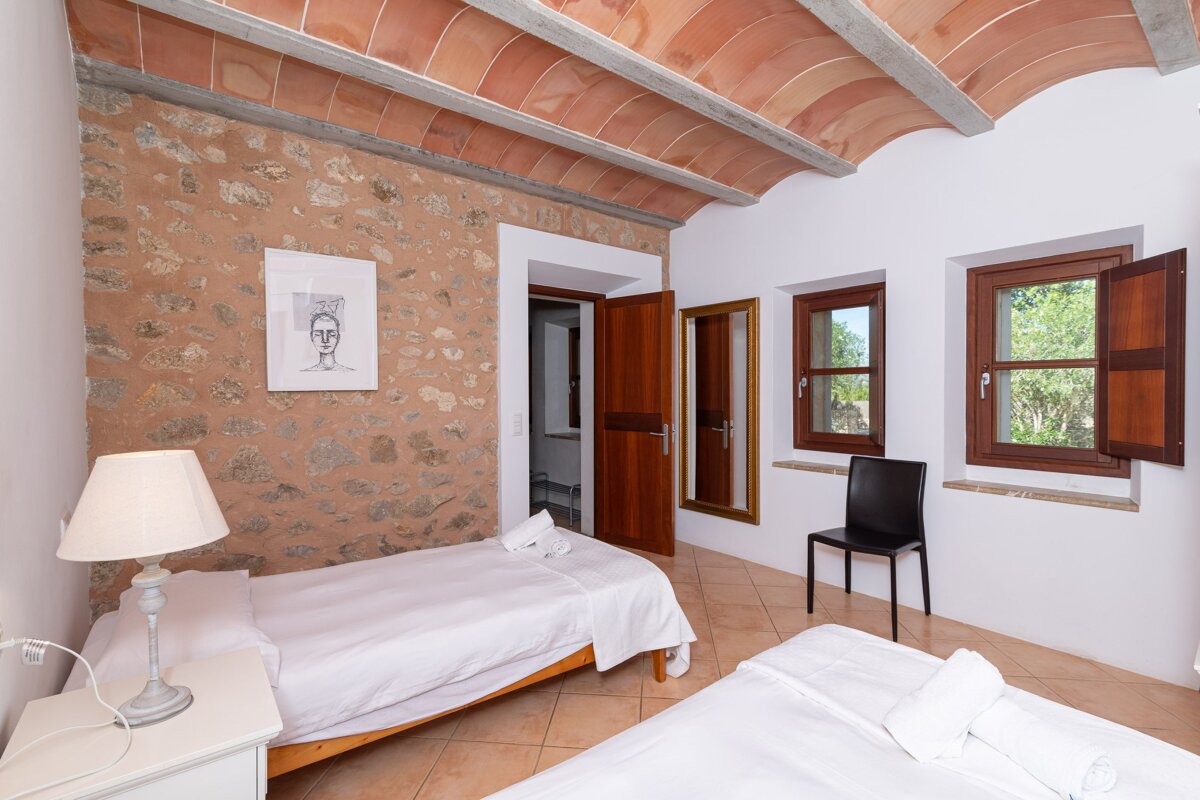 A bedroom with two beds a lamp and a picture on the wall