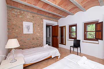 A bedroom with two beds a lamp and a picture on the wall