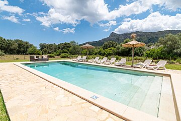 A large swimming pool with chairs and umbrellas around it