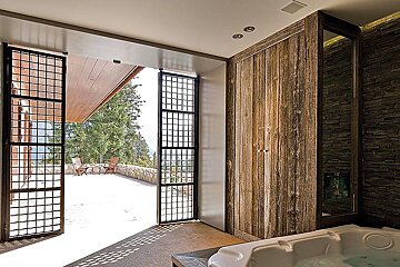 A bathroom with a jacuzzi and a view of a patio
