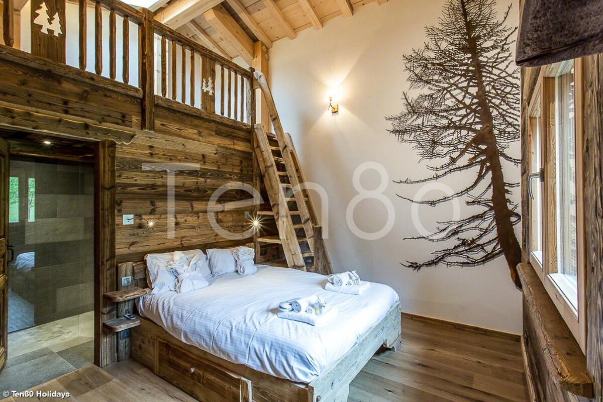 A bedroom with a bed and a ladder and the number ten80 on the wall