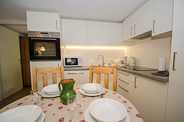 A kitchen with white cabinets and a tcl oven