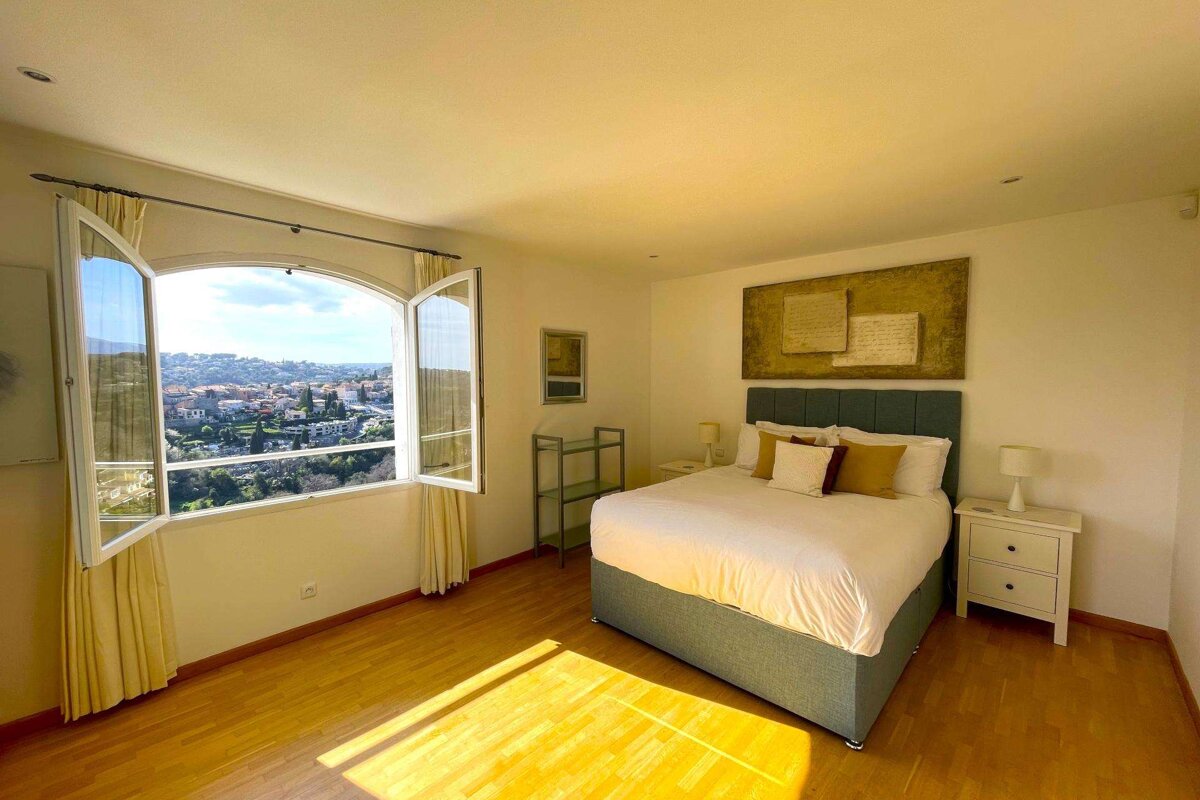 A bedroom with a large bed and a large window