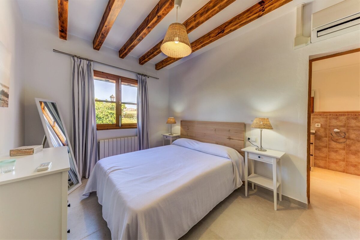 A bedroom with a bed and two lamps