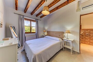 A bedroom with a bed and two lamps