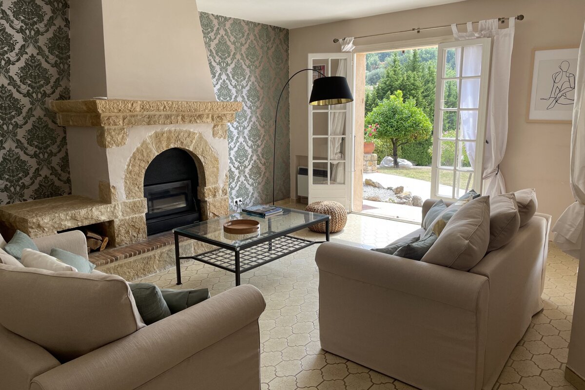 A living room with a fireplace and a glass coffee table