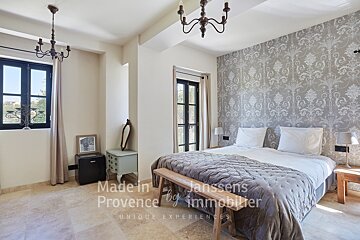 A bedroom with a bed made in provence by immobilier