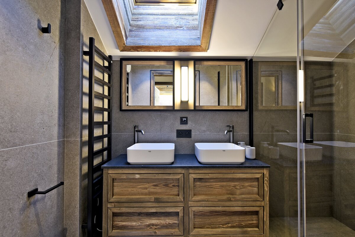 A bathroom with two sinks and a skylight above them