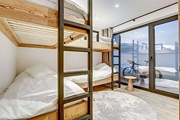 A room with bunk beds and a bicycle in the background