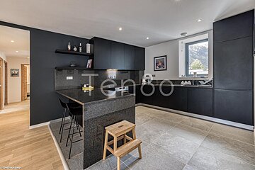 A kitchen with black cabinets and a sign that says tengo