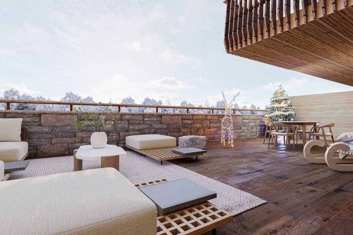 Cozy wooden patio decorated for winter with modern furniture, a Christmas tree, light-up reindeer, and a snowy view in the distance.