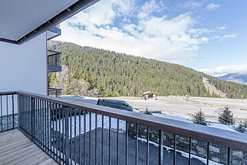 A balcony with a view of mountains and trees