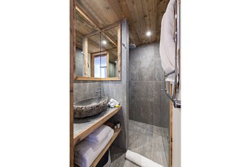 A bathroom with a sink and a walk in shower