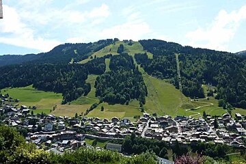 A small town in the mountains with a mountain in the background