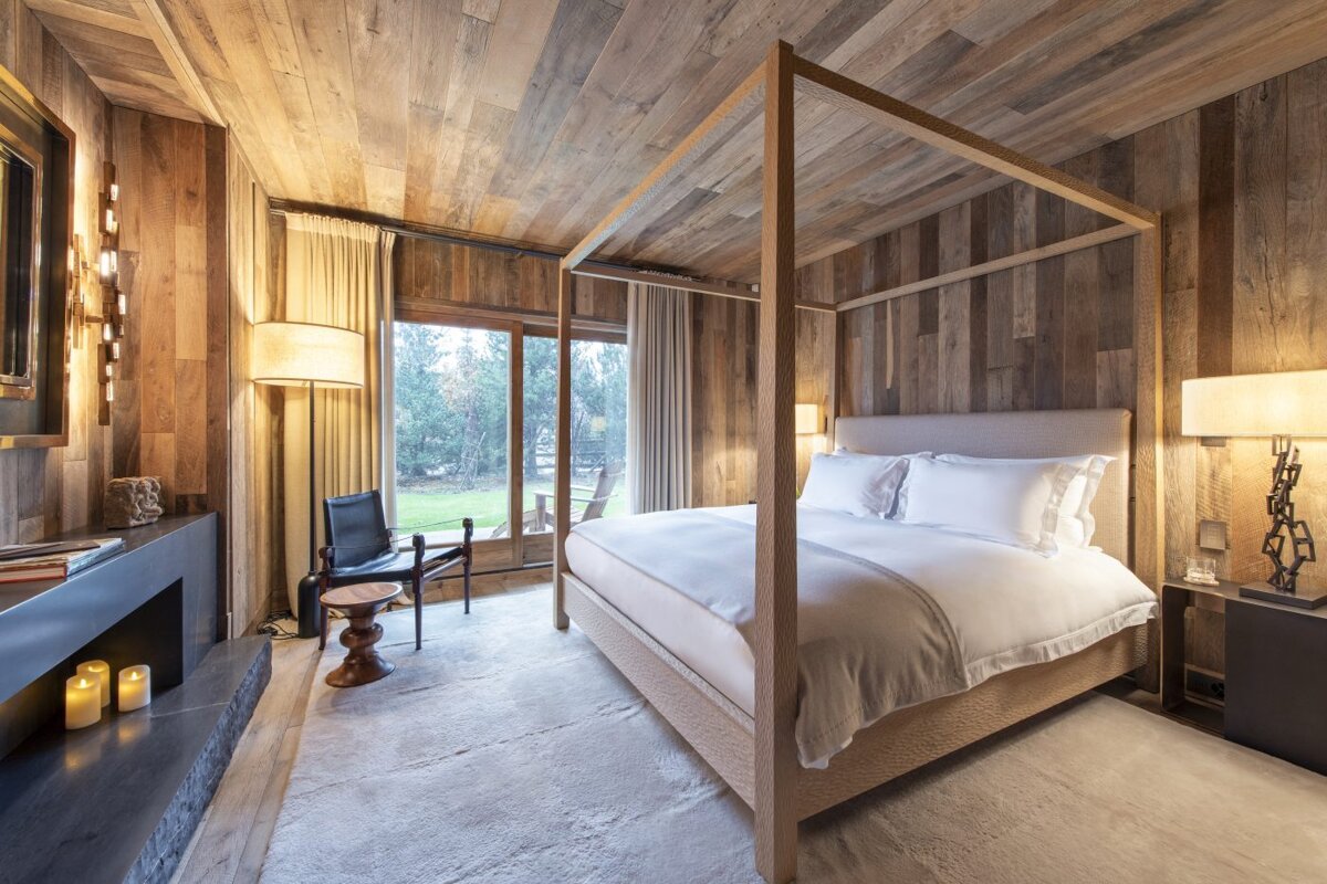 A bedroom with a four poster bed and a fireplace