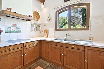 A kitchen with wooden cabinets and a stove top oven