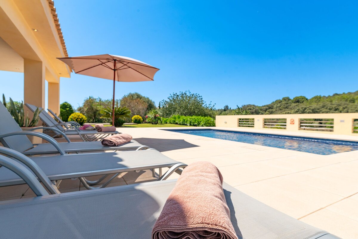 A towel is laying on a lounge chair next to a pool