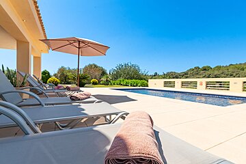 A towel is laying on a lounge chair next to a pool