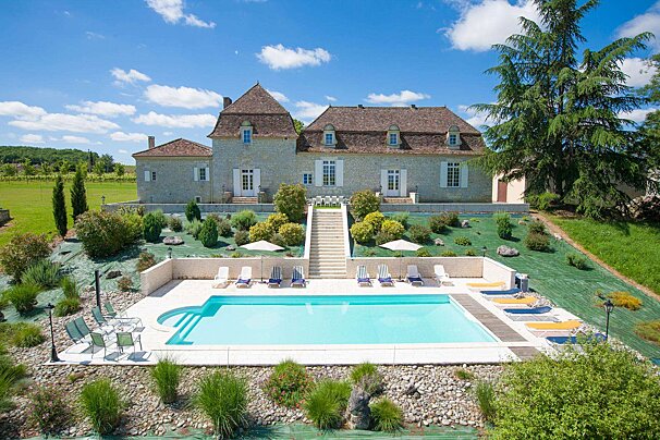 A large house with a large swimming pool in front of it
