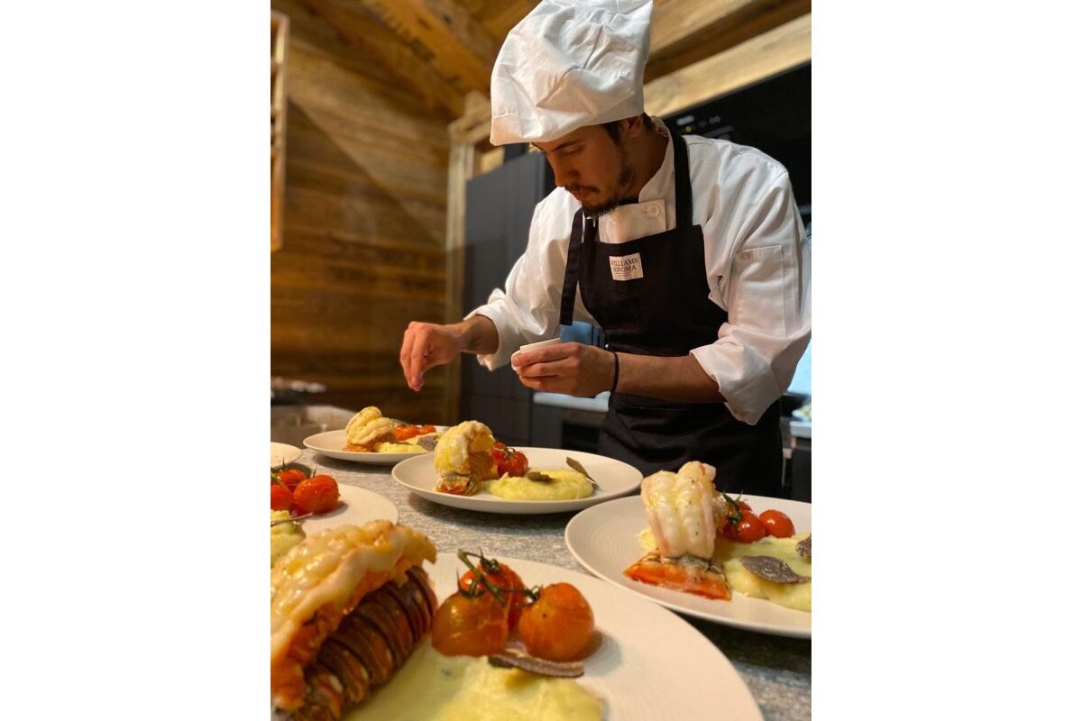 A chef wearing an apron that says ' chefs ' on it
