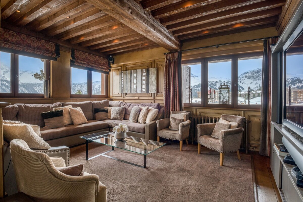 A living room with a large sectional couch and chairs