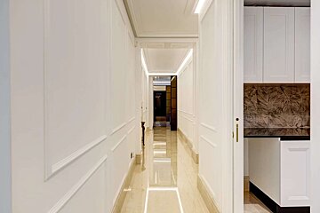 A long hallway with white walls and marble floors