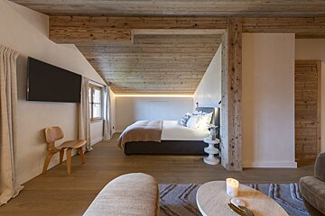 A bedroom with a large bed and a flat screen tv