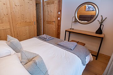 A bedroom with a large bed and a mirror