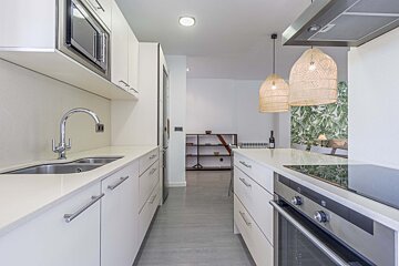 A kitchen with stainless steel appliances and white cabinets
