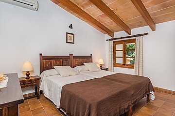 A bedroom with two beds and a picture on the wall