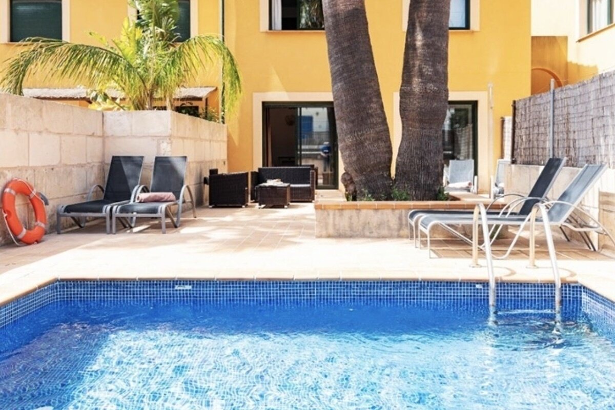 A swimming pool surrounded by chairs and a life preserver